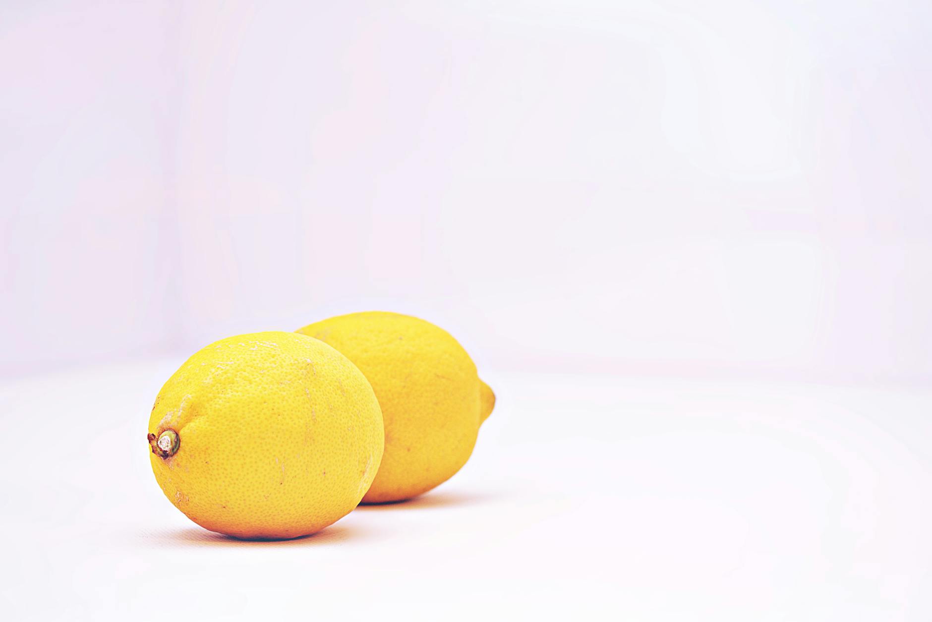Two vibrant lemons on a white background, symbolizing freshness and the journey toward reclaiming pleasure while on medication.